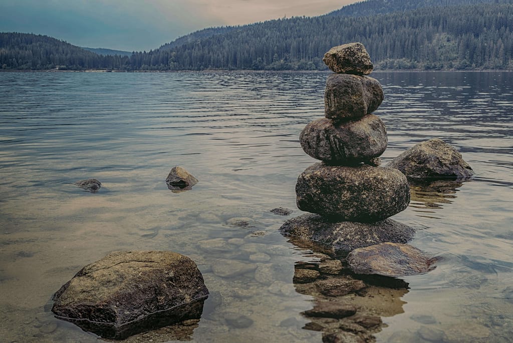 Balancierende Steine in einem ruhigen Waldsee