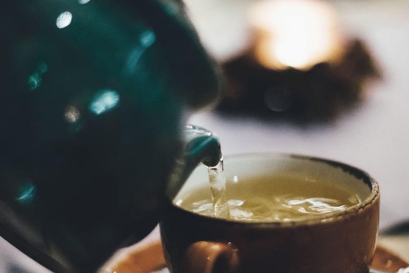 Tee wird in eine Tasse eingeschenkt