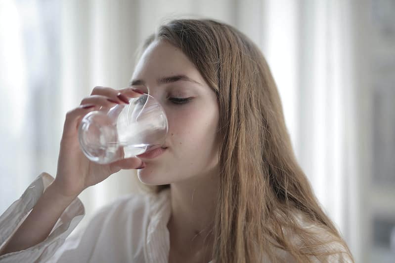 Junge Frau trinkt ein Glas Wasser