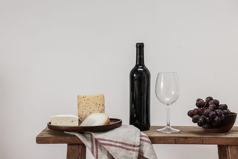 Histaminhaltige Lebensmittel - Rotwein und Käse - auf einem Tisch